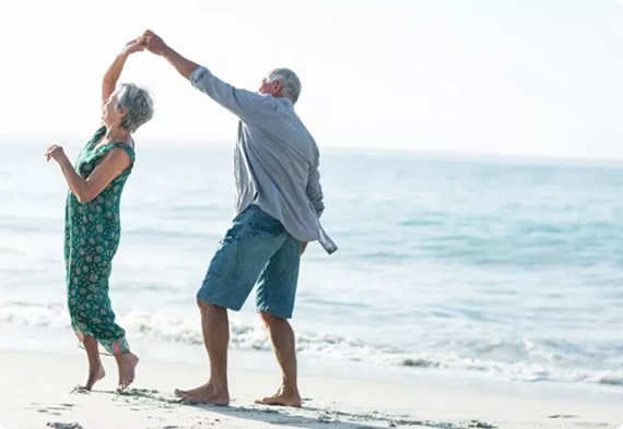 Casal de idosos feliz na praia por terem adquirido um plano funeral da internacional pax